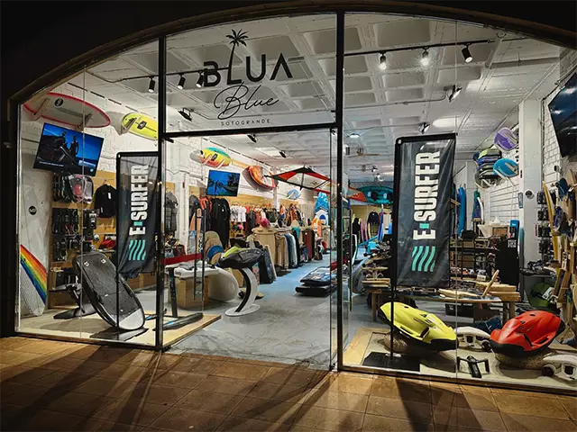 The front exterior of the Blua Blue surf shop at night.