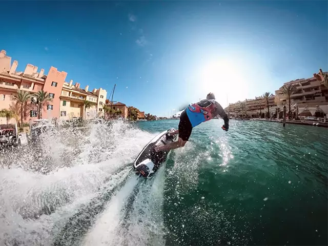 Rear view of a rider on a jetboard traveling at high speed through the Sotogrande port.